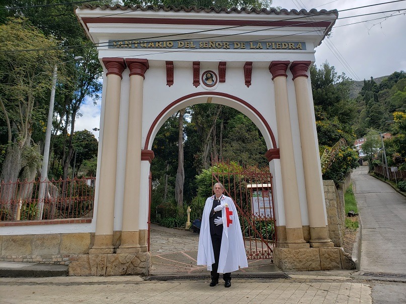 Albino Neves diante de portal arquitetônico