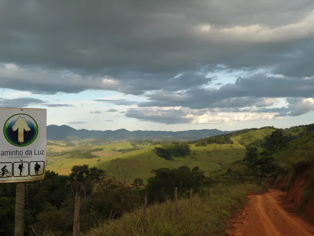Marco do Caminho da Luz diante de uma paisagem rural