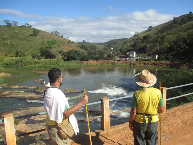 Pessoas observando um lago cercado por morros
