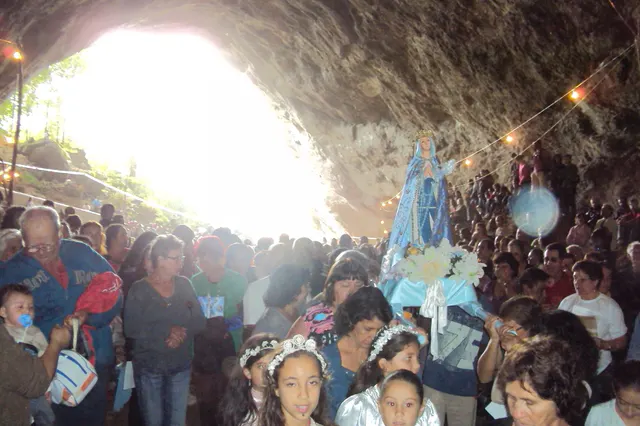 Grupo reunido em uma gruta com imagens religiosas